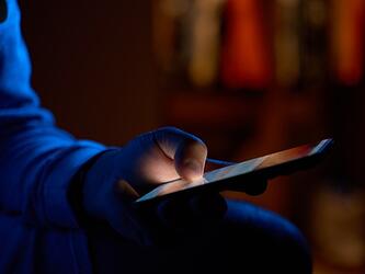 person using phone in dark room